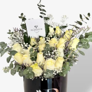 Cilindro negro con 24 rosas blancas, dólar y limonium